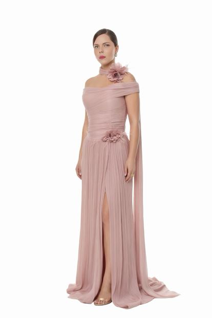 فستان سهرة بمقاسات كبيرة، بلون وردي فاتح، بياقة واسعة، وتفاصيل شال طويل، وتطريزات زهرية، وكسرات 